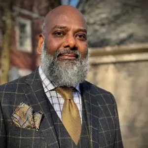 Suresh Rachuri, founder of Elevate Growth Partners, in a plaid suit and gold tie